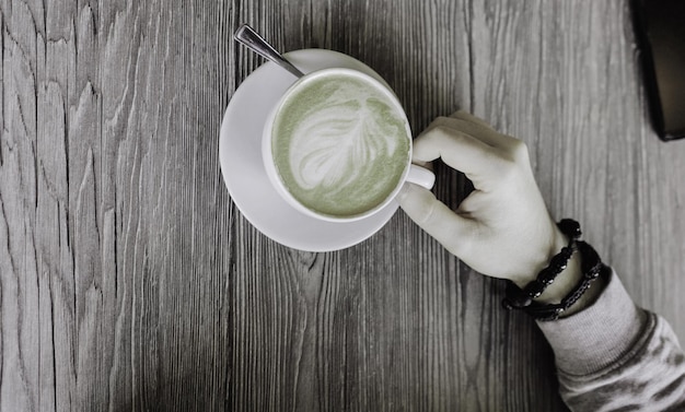 Mano d'uomo accanto a una tazza di caffè