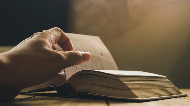 Mano dell'uomo che lancia la pagina del libro