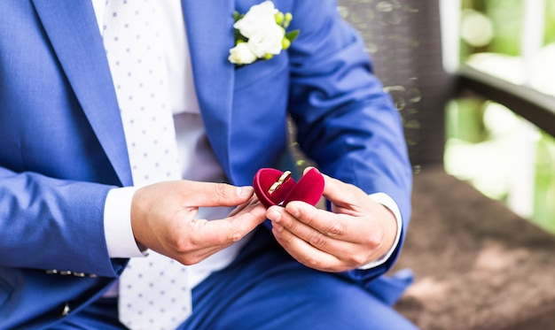 Man's hand holding engagement ring