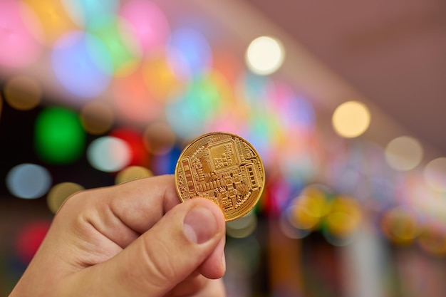 Man's hand holding golden Bitcoin