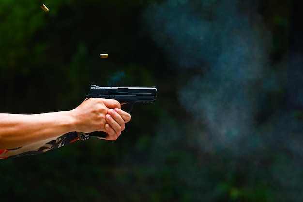 Man's hand holding gun with dark background