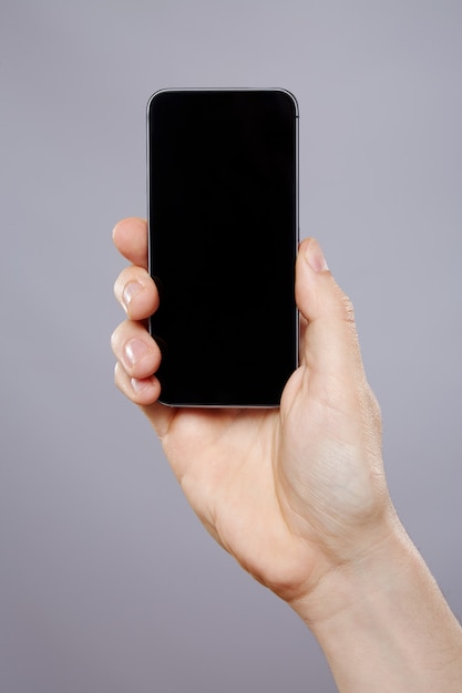 Man's hand holding a mobile phone at studio