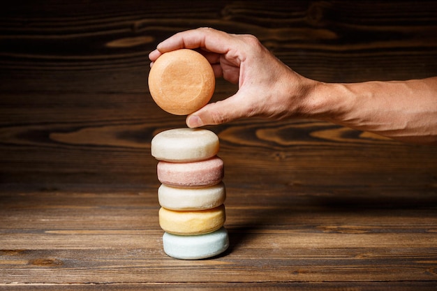 Man's hand holding round orange bar of a dry shampoo