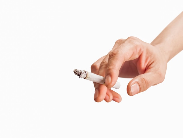 Foto mano dell'uomo che tiene una sigaretta fumante