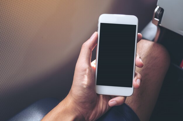 Man's hand holding a white smart phone