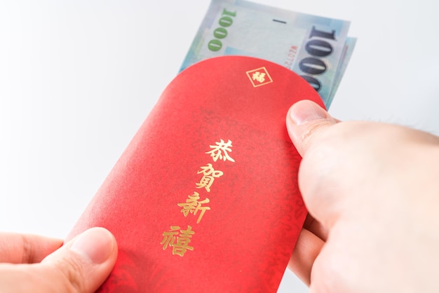 Man's hand holding with Chinese red envelope (red packet). Chinese new year concept.( Chinese "GÅnghÃ¨ xÄ«nxÇ" on it means "Wish you prosperity")