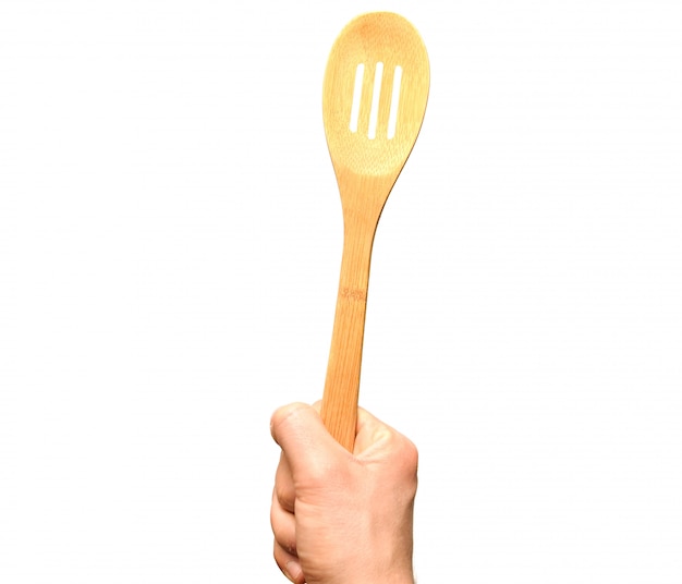 Man's hand holding a wooden spoon