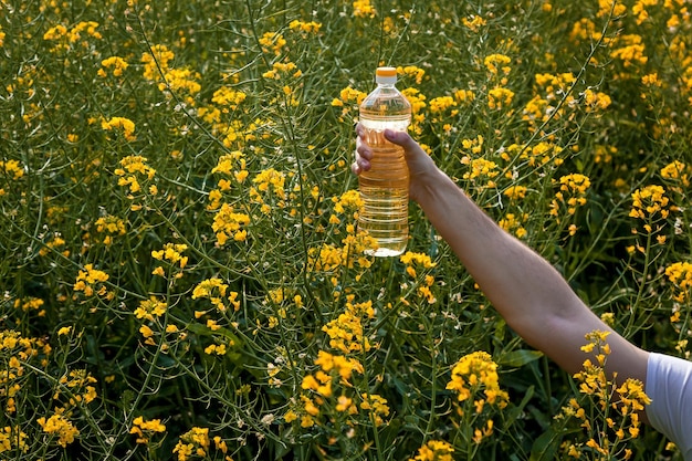 菜種油のボトルを持つ男性の手