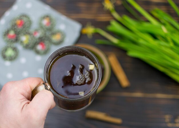 A man's hand holds a cup of tea