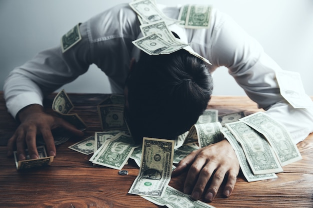 Man's hand holds dollar over table