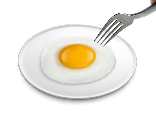 Photo a man's hand holds a fork fried egg on the plate a isolated white background