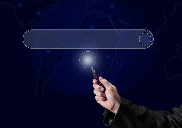 A man's hand holds a magnifying glass on the background of a template for entering and searching information on the Internet. Globalization, availability of information