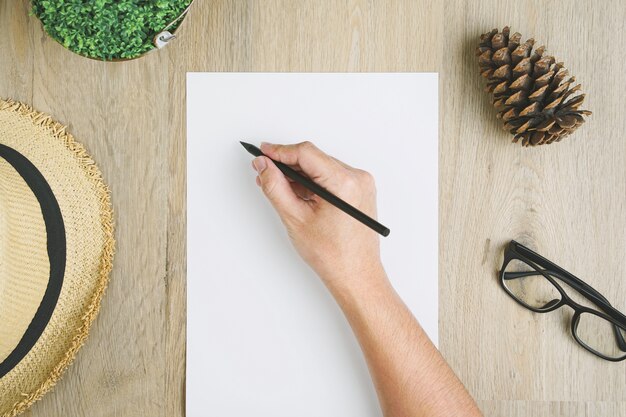 The man's hand holds a pencil written on paper.