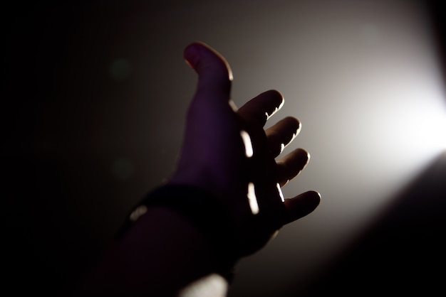 Man's hand in een lichtstraal op een zwarte