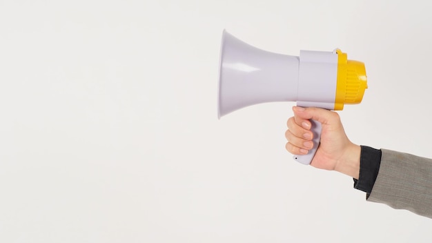 The man's hand is holding a megaphone and wears a grey suit on white background.