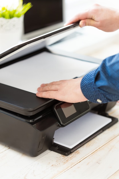 Photo man's hand making copies. working with printer