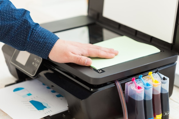 Man's hand making copies. Working with printer