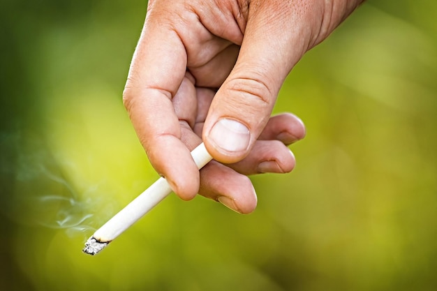 Man's hand met een brandende sigaret