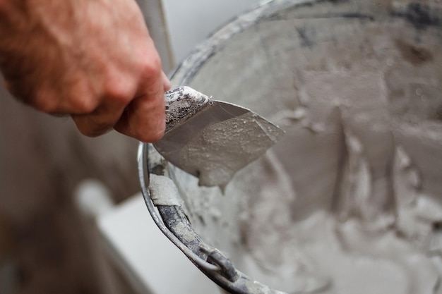 Man's hand pakt gips op een spatel