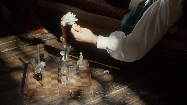 A man's hand plays chess with flasks on a chessboard premium photo