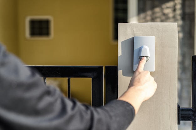 Photo man's hand pressing a doorbell button with sunlight.