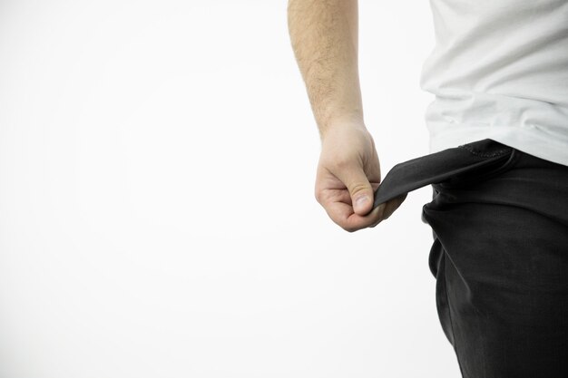 Man's hand shows an empty inside-out black pants pocket