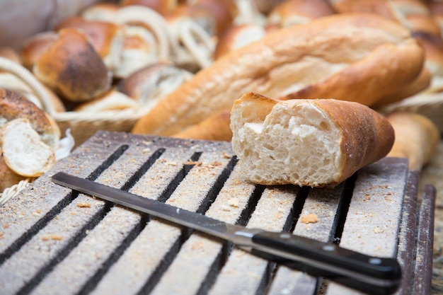 Man's hand snijden brood op een houten bord met een mes