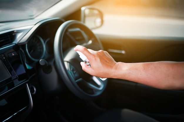 Man's hand spraying in the car