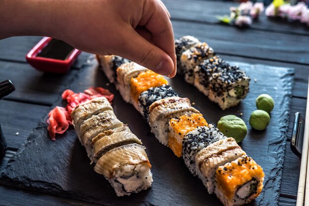 The man's hand sprinkles sesame seeds