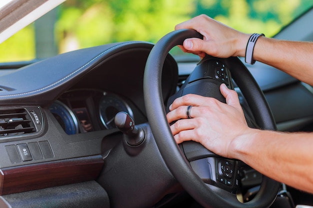 Man's hand on the steering wheel of a car