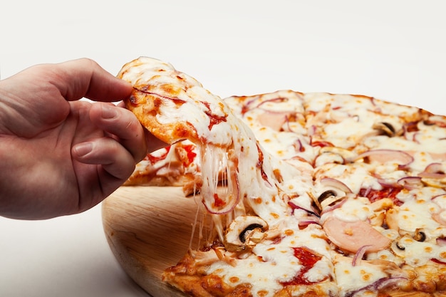 Man's hand takes a delicious slice of pizza with Margarita or Margarita with Mozzarella cheese,