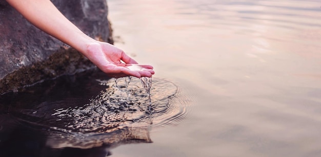 Foto la mano dell'uomo che tocca l'acqua in mezzo alla natura