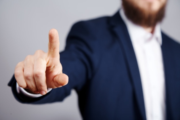 Man's hand wearing suit showing a sign at studio