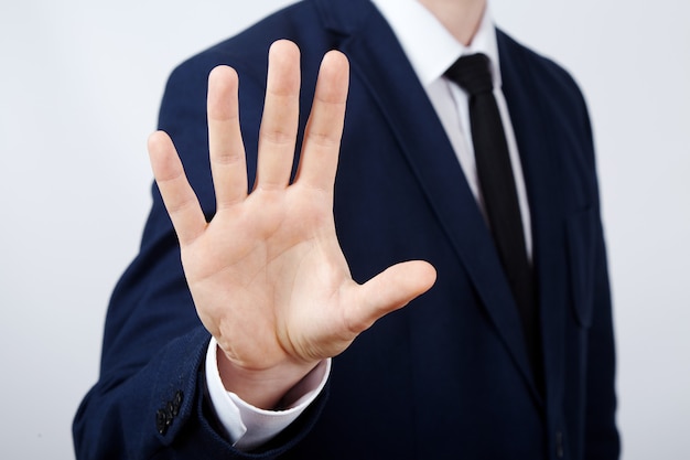 Man's hand wearing suit showing a sign at studio