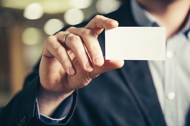 A man's hand with a business card.