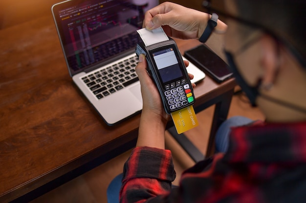 Man's hand with credit card swipe through terminal for sale,Close up of hand using credit card swiping machine to pay,vintage style