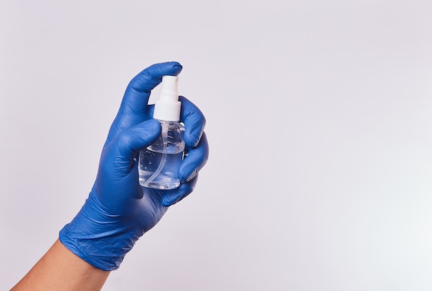 Man's hand with nitrile gloves for medicine using alcohol sprayer