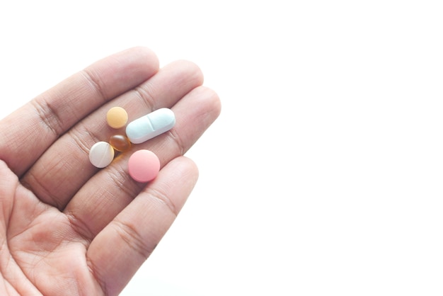 man's hand with pills and capsule isolated on white