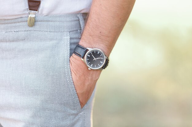 Man's hand with watch on a sunny day