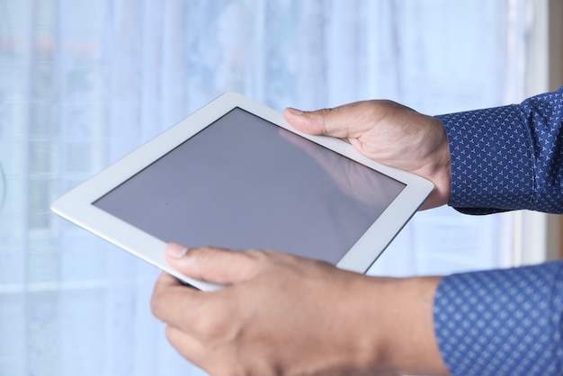 man's hand working on digital tablet at office desk, using self created chart