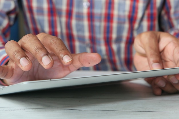 Man's hand working on digital tablet on office desk