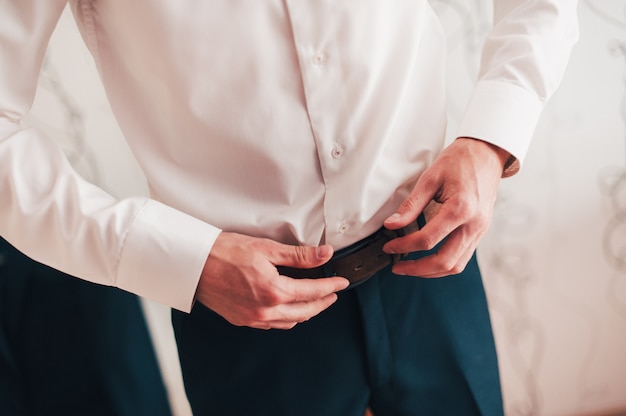 Man's hands are worn on pants