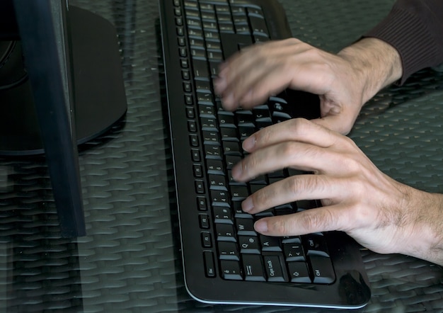 Man's hands close up on keyboard