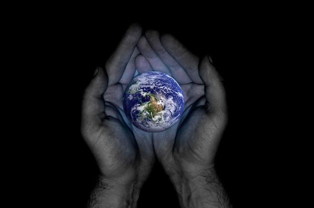 Photo man's hands hold the planet earth on a black background world environment day