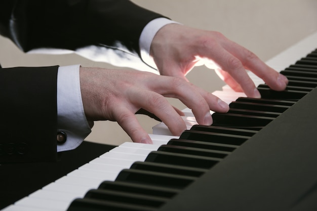 Le mani dell'uomo che giocano su un pianoforte al concerto