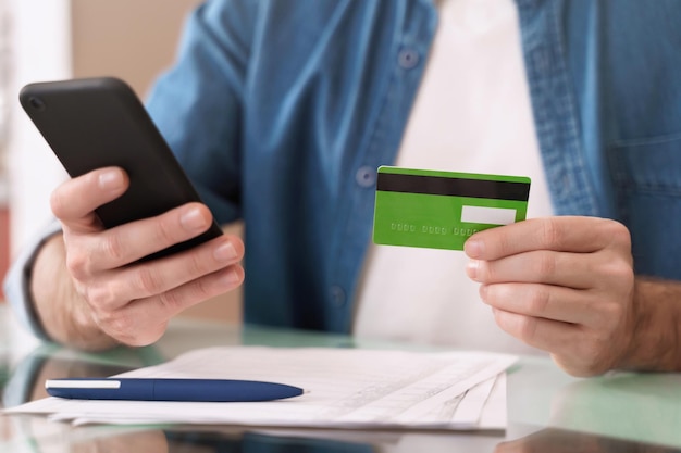 Man's hands using card and smartphone for ebanking