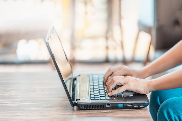 Man's hands using laptop in home.