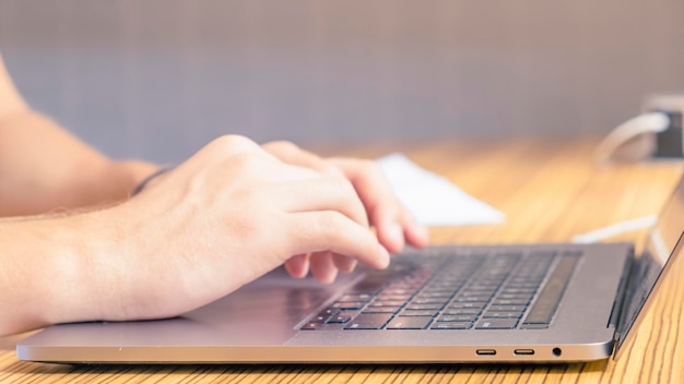 Man's hands writing on laptop