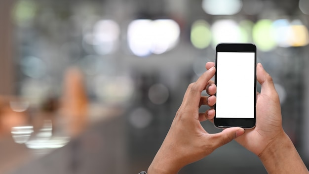 Man's holding smartphone mobile with empty screen.