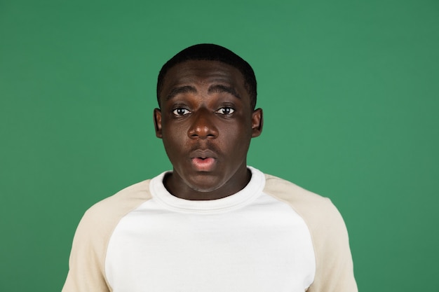 Man's portrait isolated on green studio wall